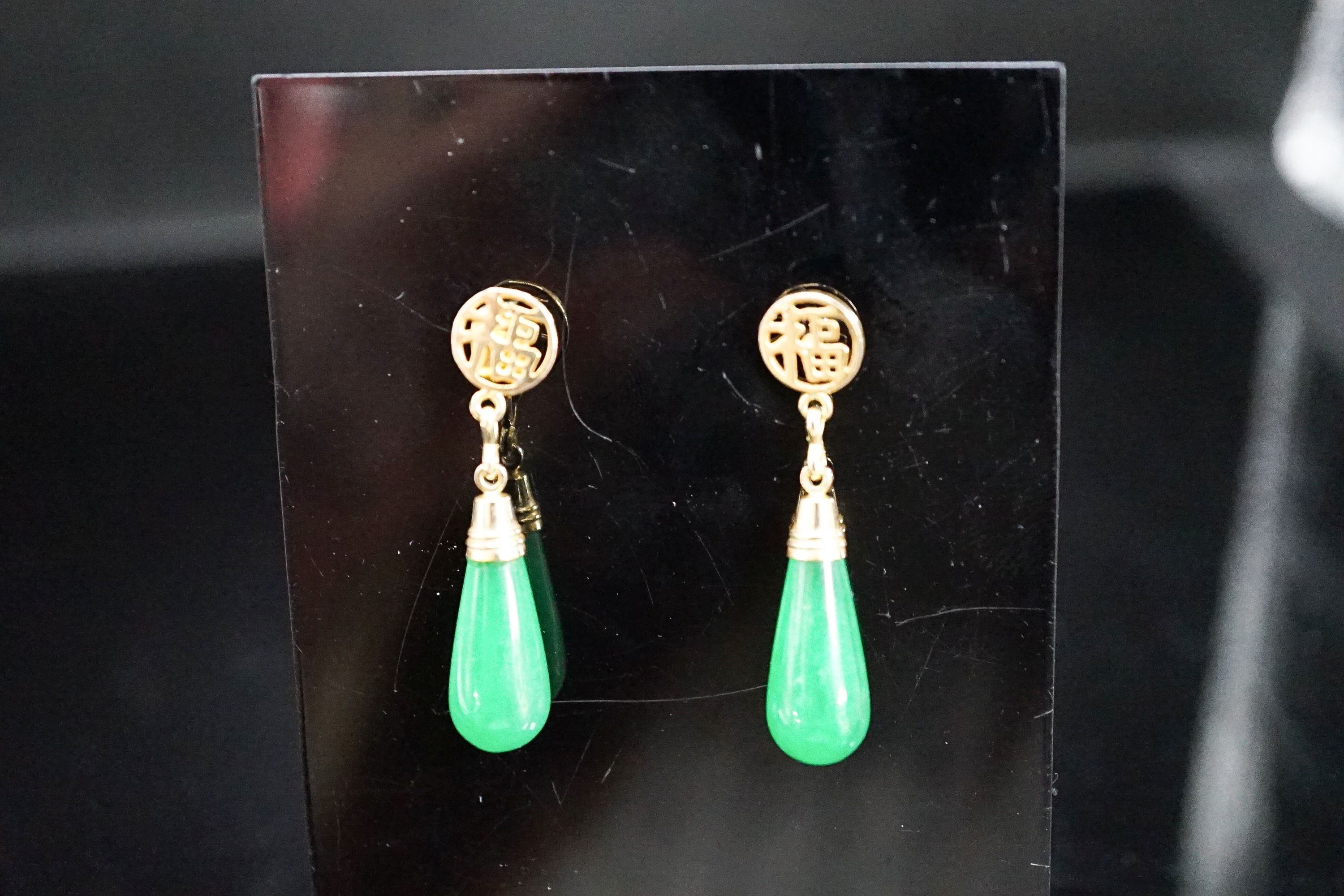 A pair of Chinese yellow metal mounted teardrop shaped jade earrings, 21mm, gross weight 5.1 grams.